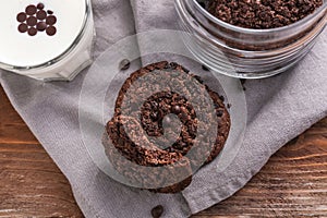 Delicious chocolate cookies and glass of milk on wooden table