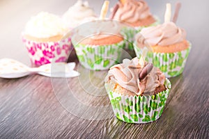 Delicious chocolate cupcakes on dark wooden table