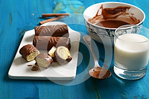 Delicious chocolate, milk and cinnamon sweets with ingredients around