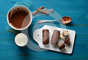 Delicious chocolate, milk and cinnamon sweets with ingredients around