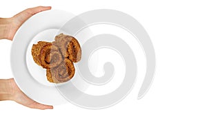 delicious chocolate with milk Swiss roll cake in hand on plate isolated on white background, home made dessert. copy space, templa