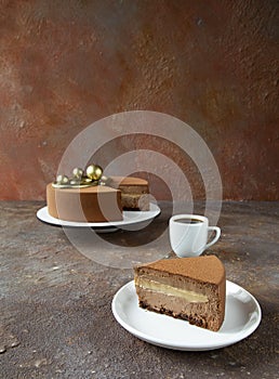 Delicious chocolate mousse cake with a cup of hot coffee on the table with an unusual texture table - dessert in the cafe