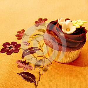 Delicious chocolate muffin on vintage tablecloth