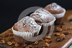 Delicious chocolate muffins on a wooden board