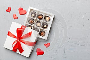 Delicious chocolate pralines in red box for Valentine's Day. Heart shaped box of chocolates top view with copy space