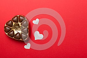 Delicious chocolate pralines in red box for Valentine's Day. Heart shaped box of chocolates top view with copy space