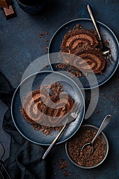 Delicious chocolate roll cake with chocolate cream on blue plate