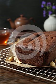 Delicious chocolate sponge cake and nuts on wooden table, closeup