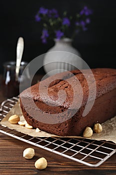 Delicious chocolate sponge cake and nuts on wooden table, closeup