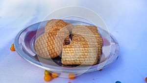 Delicious chocolate and wheat biscuits in a steel plate  on White background. Stack of round and square shape cookies with