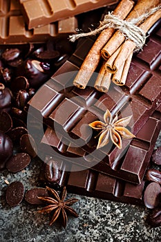 Delicious chocolates and spices on a dark background.