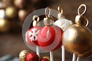 Delicious Christmas ball cake pops on blurred background, closeup