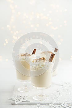 Delicious Christmas cocktail eggnog with whipped cream and cinnamon