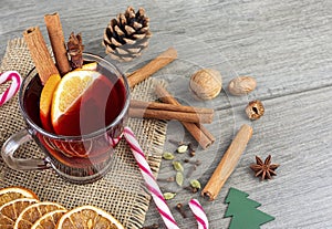 Delicious Christmas hot mulled wine, candy Christmas cane and spices on wooden background