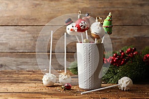 Delicious Christmas themed cake pops on wooden table. Space for text