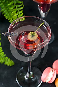 Delicious cocktails with campari, gin, vermouth, and a berries. Refreshing summer drink on stone or concrete background
