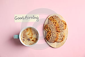 Delicious coffee, cookies and card with words GOOD MORNING on pink background