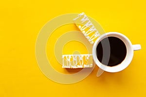 Delicious color bright cakes and coffee cup. Bright yellow background