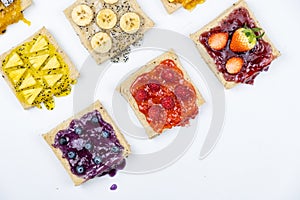 Delicious colourful minimal mix fruits jam on sliced bread. Set on white background