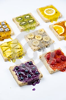Delicious colourful minimal mix fruits jam on sliced bread. Set on white background