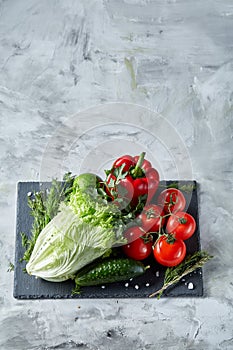 Delicious composition of assorted fresh vegetables and herbs on white textured background, top view, selective focus.