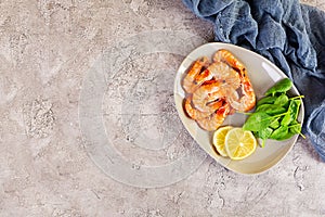 Delicious cooked shrimps in plate isolated on grey background. Boiled prawns