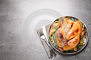 Delicious cooked turkey with garnish on grey table, top view with space for text. Thanksgiving Day celebration