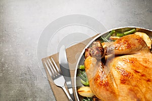 Delicious cooked turkey with garnish on grey table, top view with space for text. Thanksgiving Day celebration