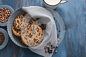 Delicious cookies with chocolate and cup of milk on color wooden background