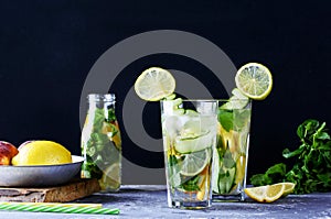 Delicious cool fruit lemonade. Fresh fruits and mint. Drink on a dark background