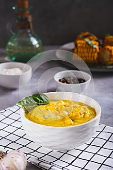 Delicious corn cream soup in a bowl on the table vertical view