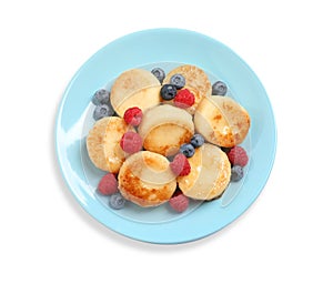 Delicious cottage cheese pancakes with fresh berries and honey on white background, top view