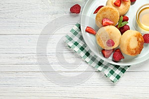 Delicious cottage cheese pancakes with fresh berries and honey on white wooden table, flat lay. Space for text