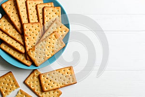 Delicious crackers on white wooden table, flat lay. Space for text