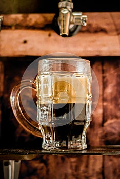 Delicious craft beer in a pint glass on wooden background