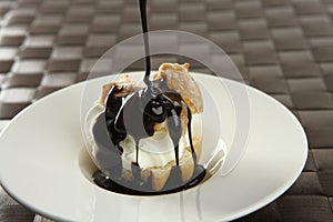 Delicious cream puff cake with chocolate syrup photo