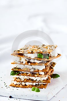 Delicious crispy crackers with cheese and basil