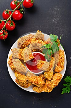 Delicious Crispy Fried Breaded Chicken Breast Strips with Ketchup on Dark Background