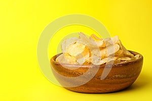 Delicious crispy potato chips in bowl, space for text