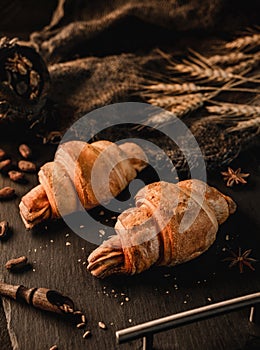 Delicious croissant with chocolate on slate background. Pastries and bakery, close up