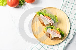 Delicious croissant sandwich with fresh Ham, cheese,  tomato, cucumber and lettuce on white background.