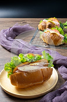 Delicious croissants sandwich served on sieve and Sub sandwich served on wooden plate.