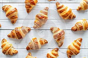 Delicious croissants on a white wooden background. Flat lay shot