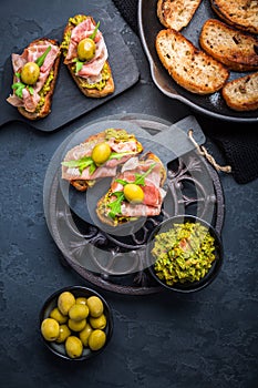 Delicious crostini with avocado spread and serrano or prosciutto ham