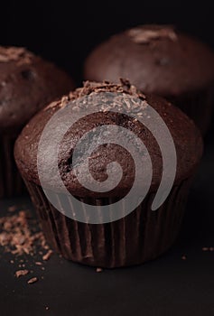 Delicious cupcakes with chocolate crumbles on black table, closeup