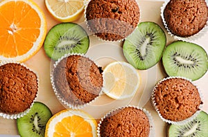 Delicious cupcakes with different cuts of juicy fruit