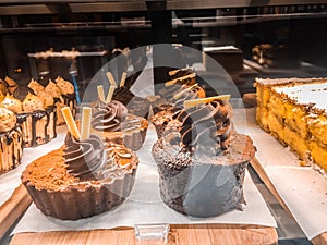 Delicious cupcakes displayed in eatery storefront window.