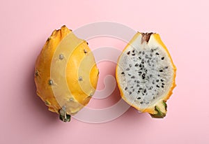 Delicious cut and whole dragon fruits pitahaya on pink background, flat lay