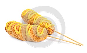 Delicious deep fried corn dogs with mustard on white background