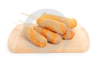 Delicious deep fried corn dogs with wooden board isolated on white